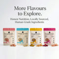 Four Whisker & Wilde cat treat flavour packages lined up with pieces of treats in front